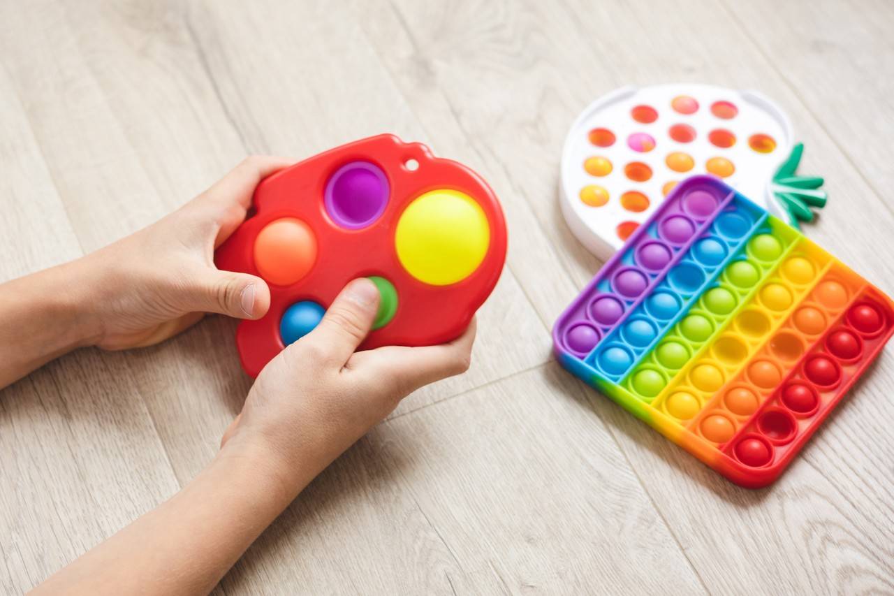 criança brincando com brinquedo antiestress