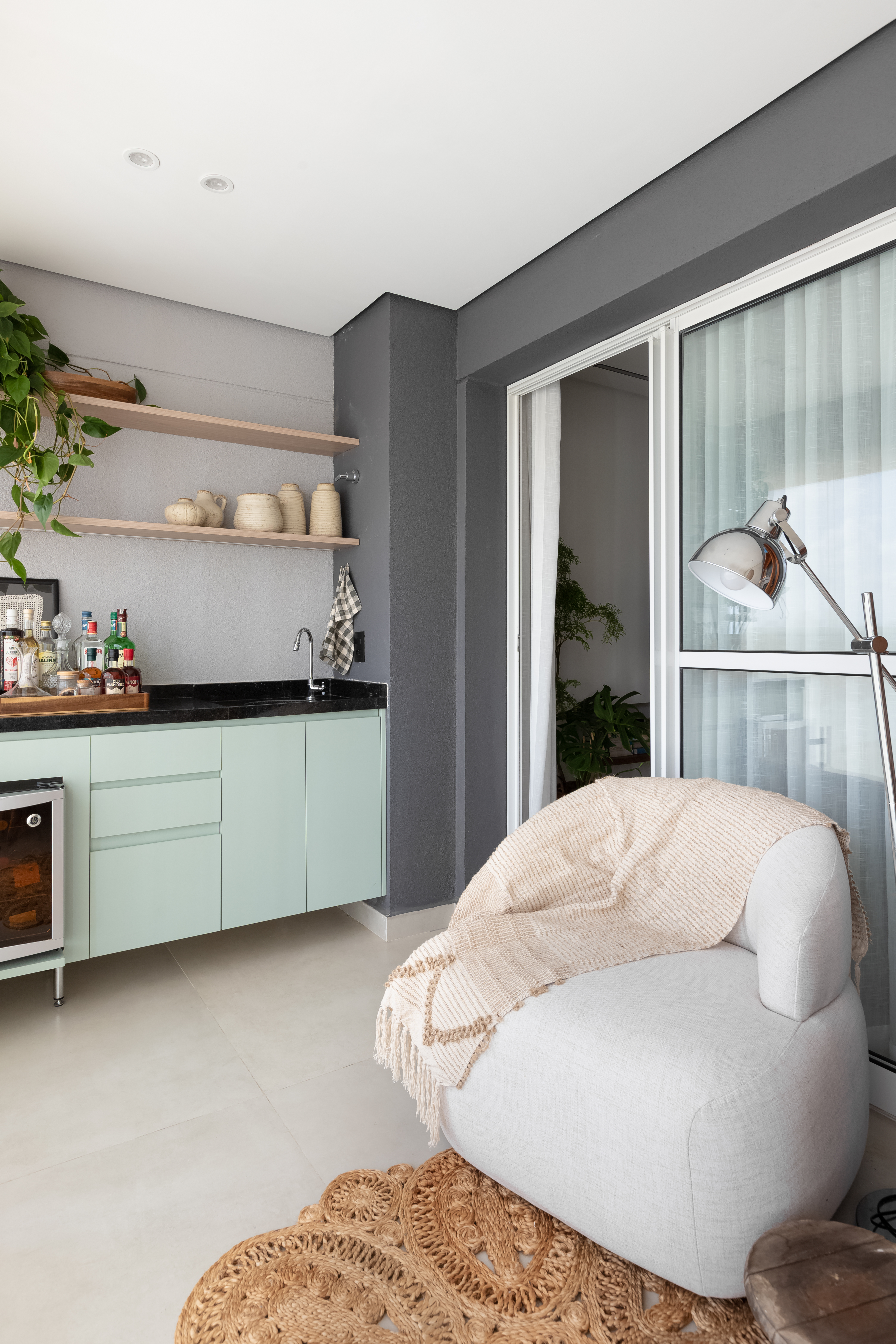 varanda com poltrona de leitura e bar com adega.