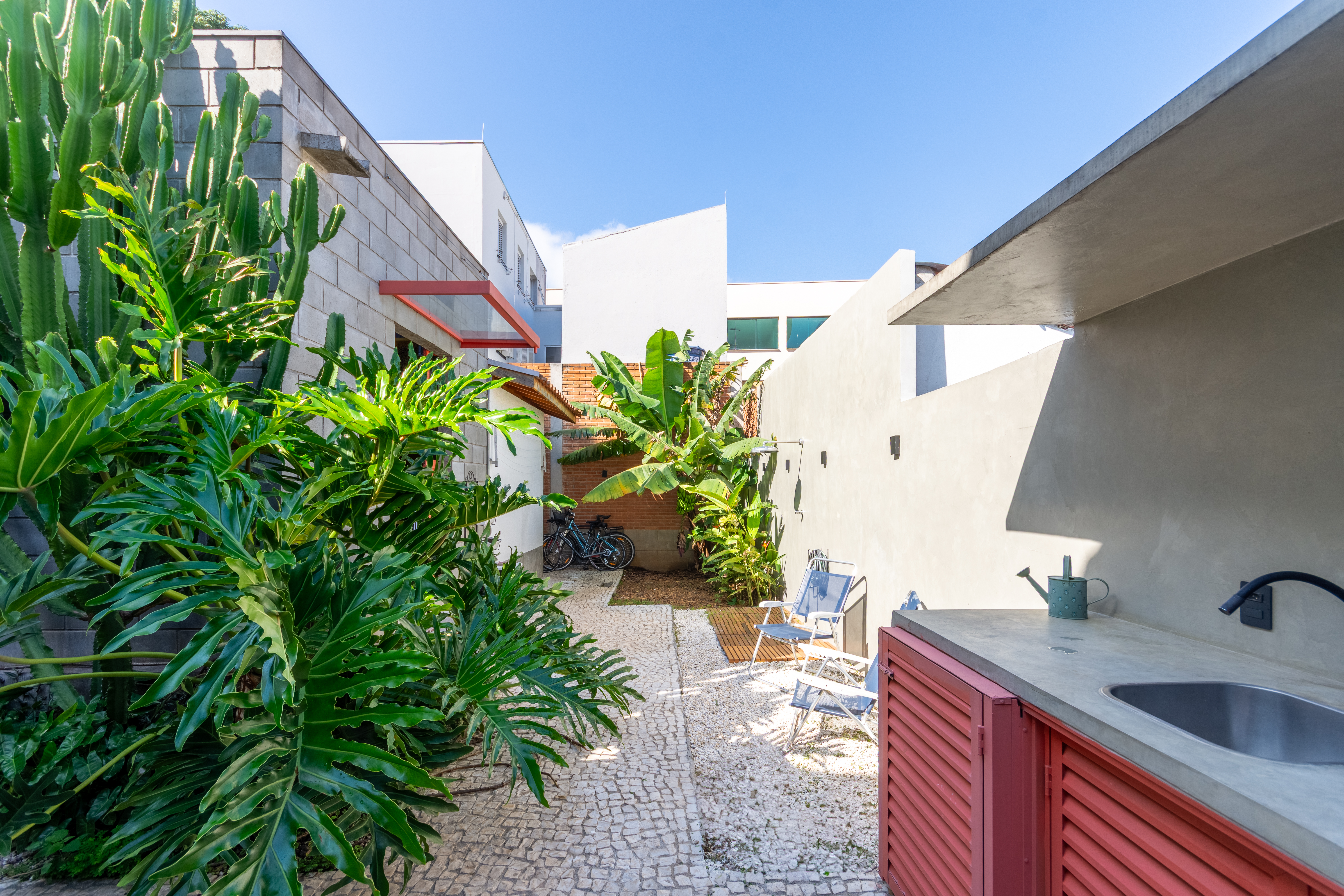 Jardim integrado à casa com área externa e churrasqueira para momentos de convivência