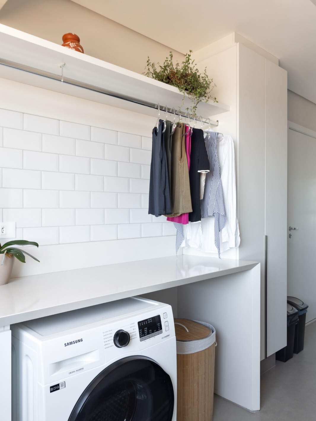 lavanderia branca com bancada funcional e espaço para organizar roupas