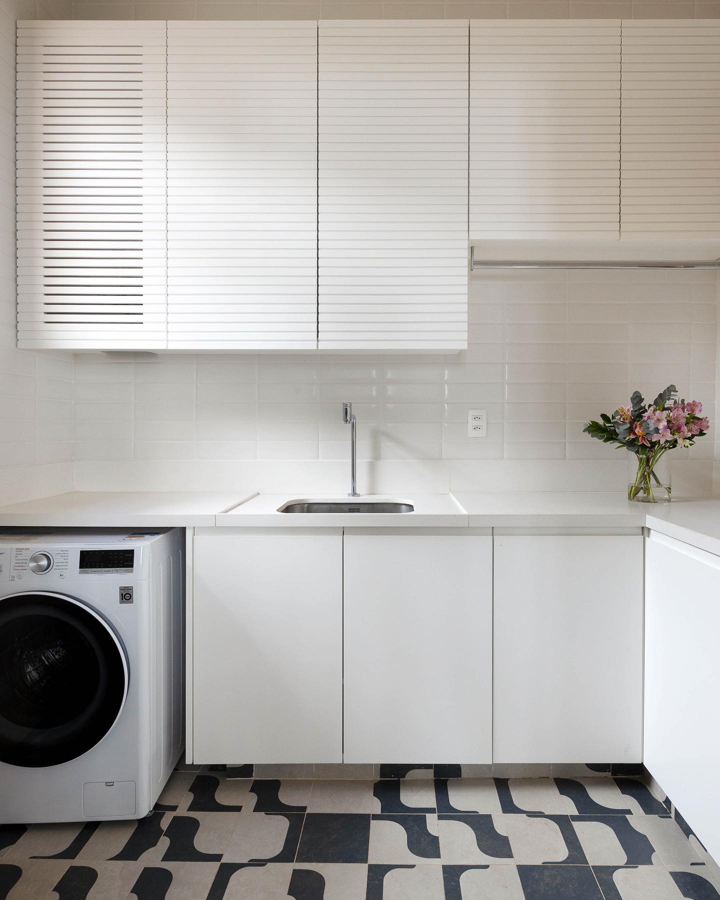 lavanderia branca com piso estampado e armários minimalistas